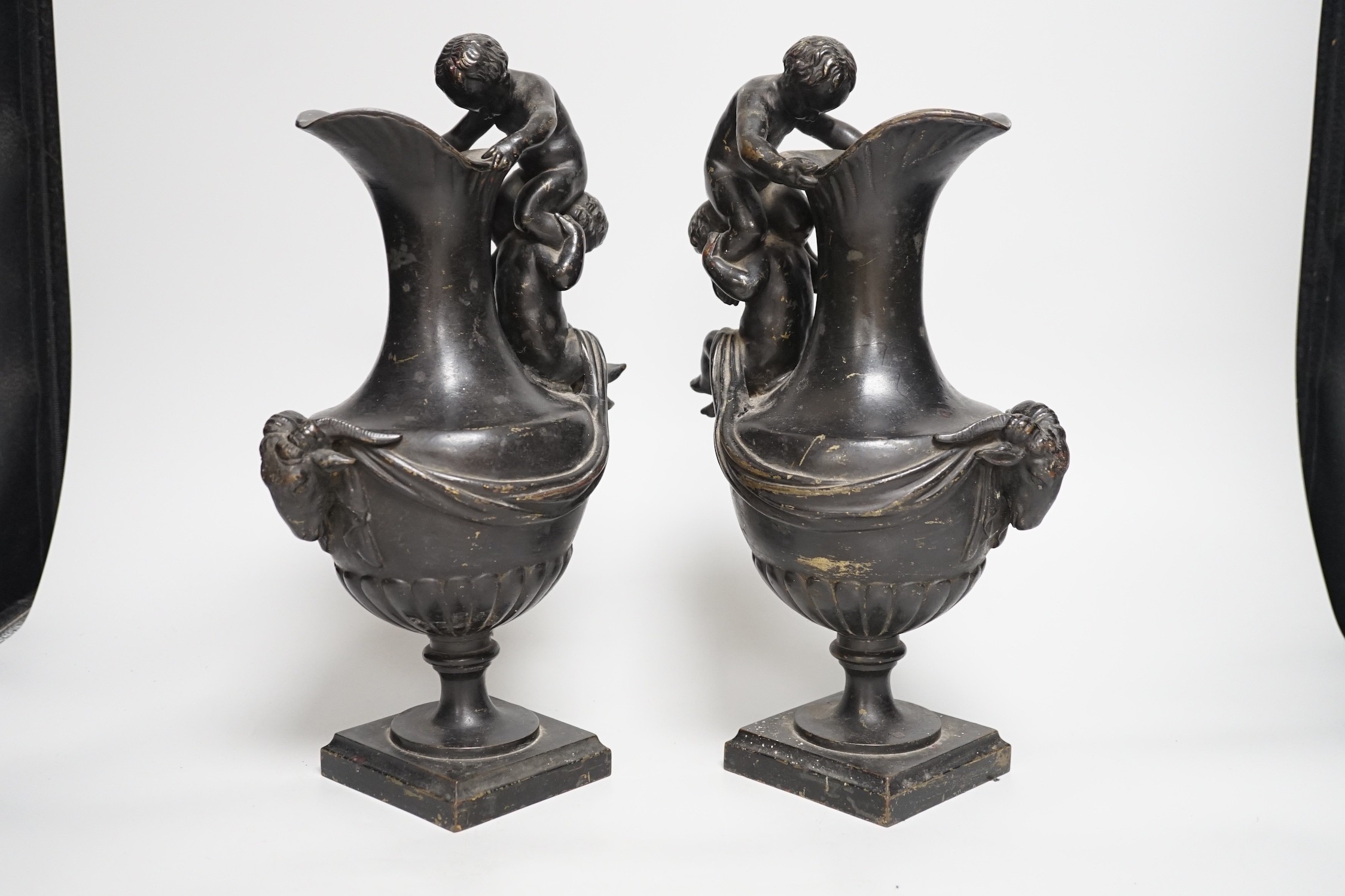 A pair of classical revival bronze urn side ornaments with cast rams head bodies. 32cm tall